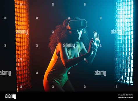 Anonymous Astonished Ethnic Female With Open Mouth Exploring Virtual Reality In Headset On Black