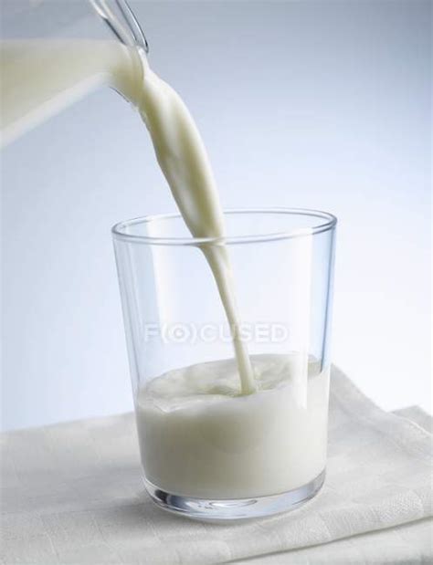 Pouring Milk Into Glass — Milk Pouring Raw Stock Photo 148478301