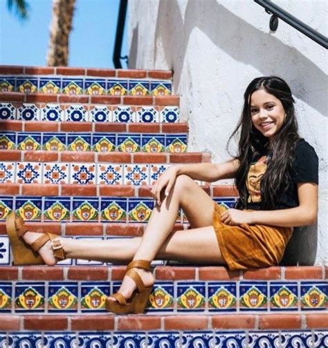 A Beautiful Young Woman Sitting On Top Of A Set Of Stairs Next To Tiled Steps