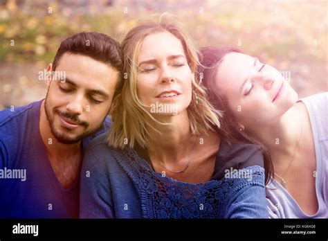 Portrait Of Three Friends Sitting Outside And Relaxing In The Sun Stock