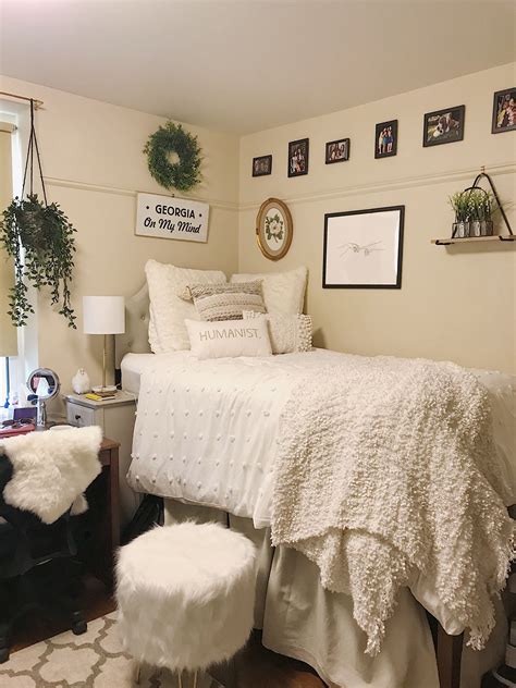 A Bedroom With White Bedding And Pictures On The Wall Above It Along
