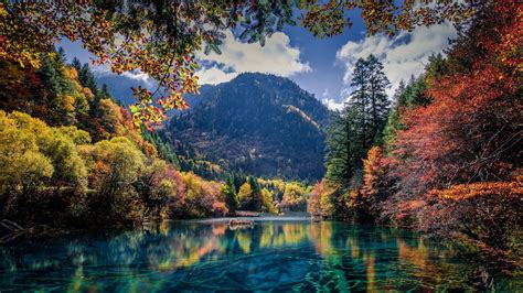 Lake Between Red And Green Leafed Trees With Long View Of Mountains