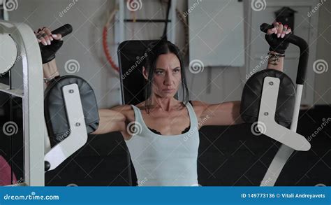 Beautiful Athletic Woman Trains The Pectoral Muscles On The Simulator