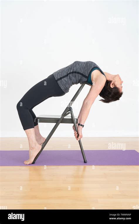 A Year Old Woman Yoga Instructor In Her Studio Shows Iyengar Yoga Chair Backbend Stock Photo