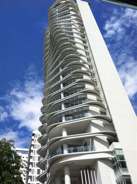 A Tall White Building With Balconies On The Top And Bottom Floors