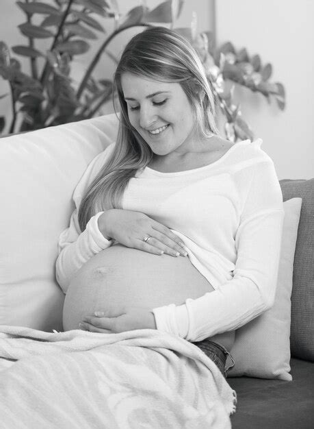 Premium Photo Black And White Portrait Of Smiling Pregnant Woman Lying On Sofa And Touching Belly