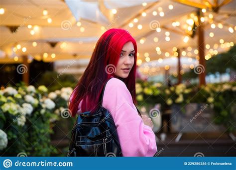 Beautiful Red Haired Girl In The Evening On A Lighted City Street