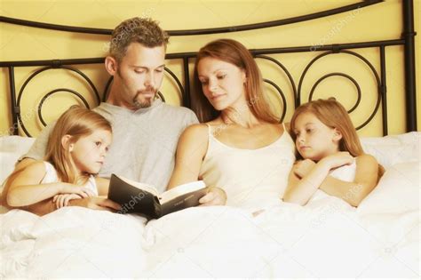 Familia En La Cama Leyendo La Biblia — Fotos De Stock © Designpicsinc 31681457