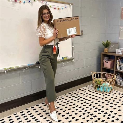 teacher holding her teacher style box in her classroom cute teaching outfits cute teacher