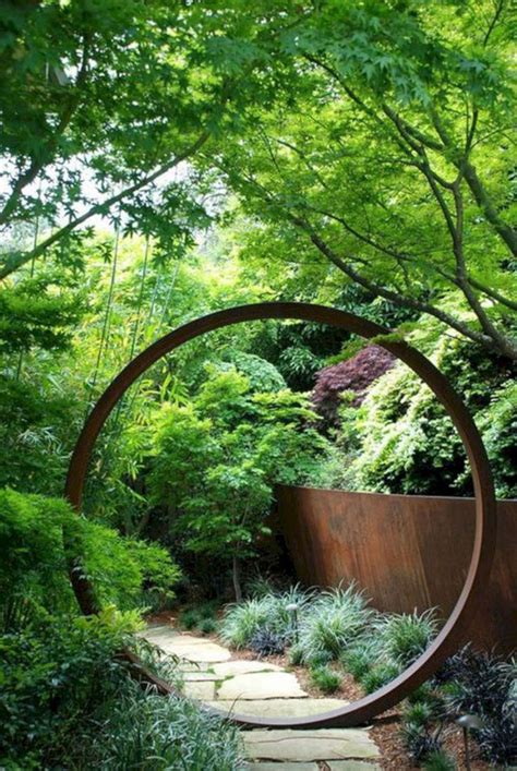 A Circular Metal Sculpture In The Middle Of A Garden Filled With Trees