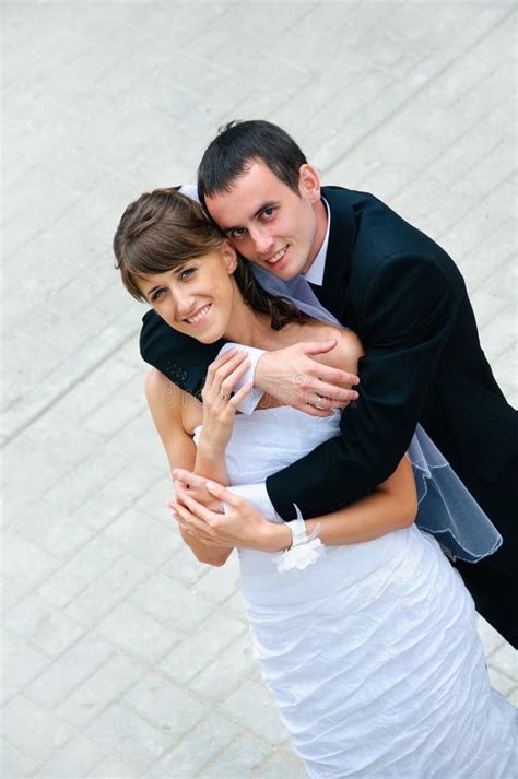 Happy Wedding Couple Standing Kissing And Embracing Stock Photo