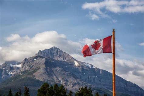 Canadian Flag With Rockie Mountains In The Background Stock Image