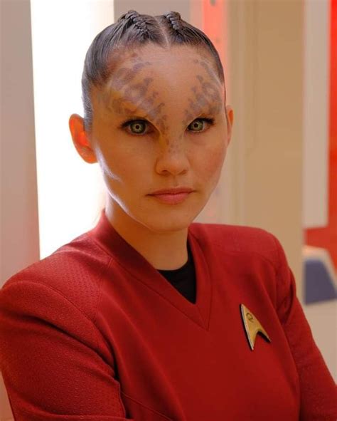 a woman with freckles on her face and hair is wearing a star trek uniform