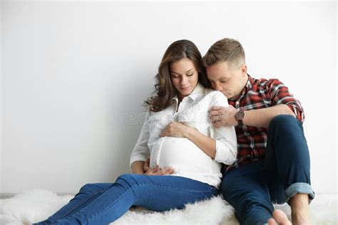 Pregnant Woman With Her Husband Near White Wall Stock Image Image Of Floor Love 131008701