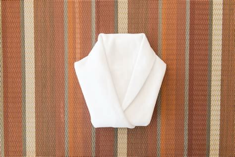 Premium Photo White Napkin Folded Into A Shirt On Dinner Table