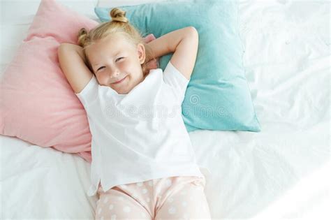 Little Girl In Bed With White Linen A Child At Home In The Morning