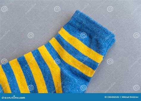 blue and yellow socks against a gray background a pair of bright colorful striped socks stock