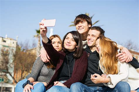 group of teen friends taking a selfie with their phone outside by stocksy contributor