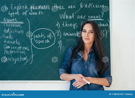 Portrait Of Female English Teacher In Front Of Blackboard Stock Photo