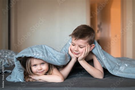 Brother Is Watching His Sister On The Bed Buy This Stock Photo And