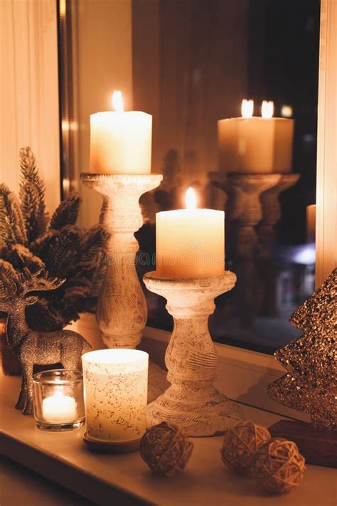 Burning Candles And Christmas Decor On Window Sill At Night Stock Image