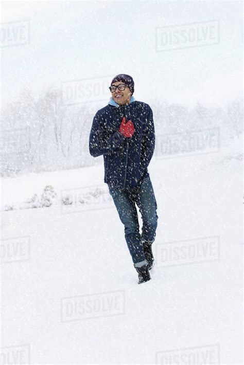 Mid Adult Man Walking On Snow Stock Photo Dissolve