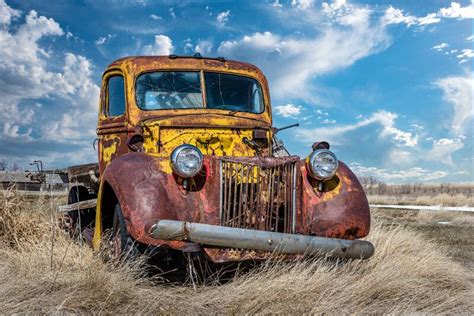 An Abandoned Vintage Yellow And Red Truck On The Saskatchewan Prairies