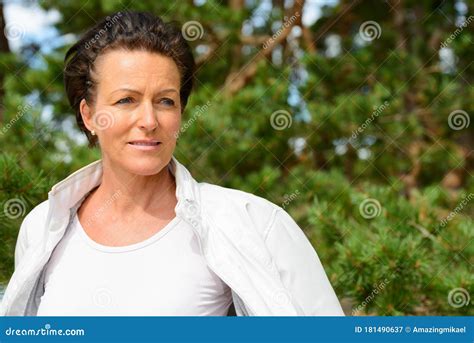 Mature Beautiful Woman Against Healthy Bushes In Nature Stock Image