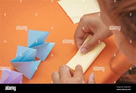 Childrens Hands Do Origami From Colored Paper On White Background