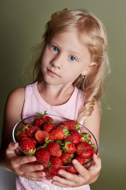 Premium Photo Young Girl Eats Strawberries Cheerful Emotions