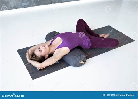 Woman Practicing Yoga Lying In Reclined Butterfly Exercise Stock Photo