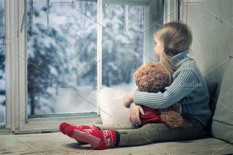Looking Through Snowy Window At Home Happy Child With Teddy Bear