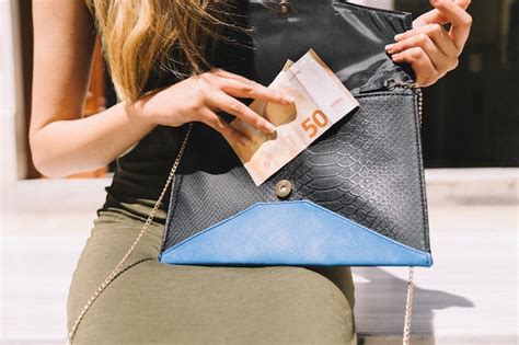Mulher Tirando Dinheiro De Seu Bolso De Mão Foto Grátis