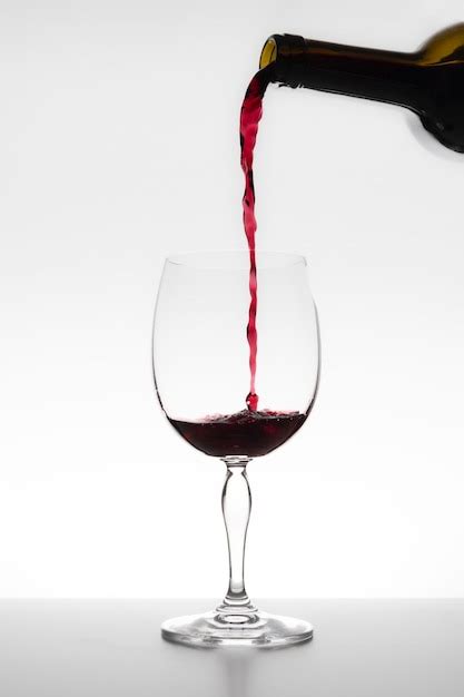 Premium Photo Red Wine Falling In Glass On White Background