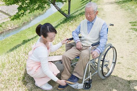 Senior Man Sitting On A Wheelchair With Caregiver Stock Image Image