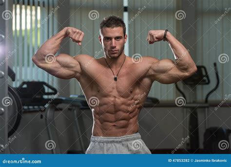 Hombre Joven Front Double Biceps Pose De Ejecución Foto De Archivo
