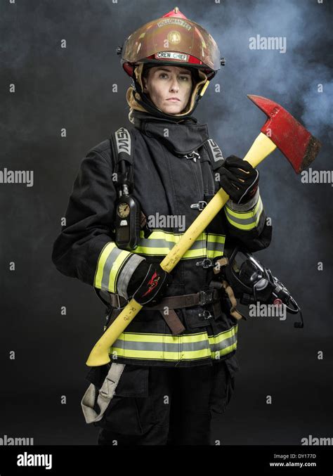 Female Firefighter In Structural Firefighting Uniform With Breathing Apparatus And Axe Stock