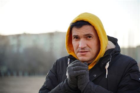 Young Frozen Man In Yellow Hood And Black Jacket Adult Male Warming