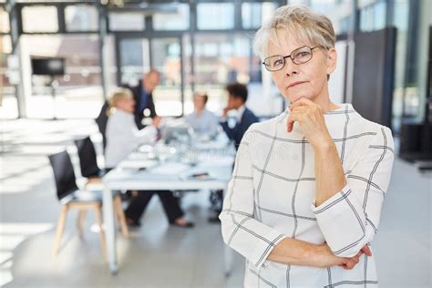 Thoughtful Senior Woman As Boss In The Meeting In The Office Stock