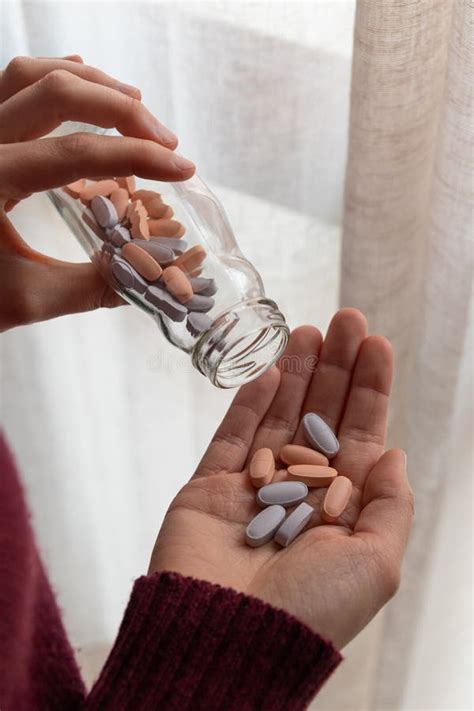 Close Up Of Woman`s Hands With A Bottle Of Pills And Some Pills In Her