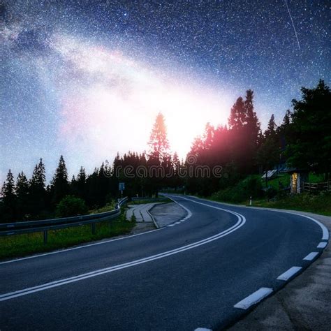 Asphalt Road And Lonely Tree Under A Starry Night Sky And The Milky Way