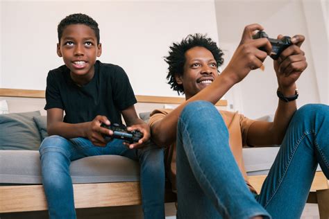 Father And Son Playing Video Games Together At Home Anlx