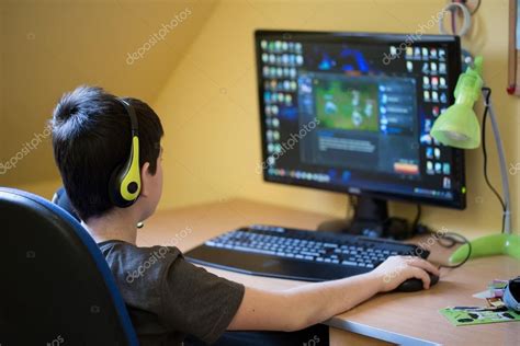 Boy Using Computer At Home Playing Game — Stock Photo © Artush 69787517