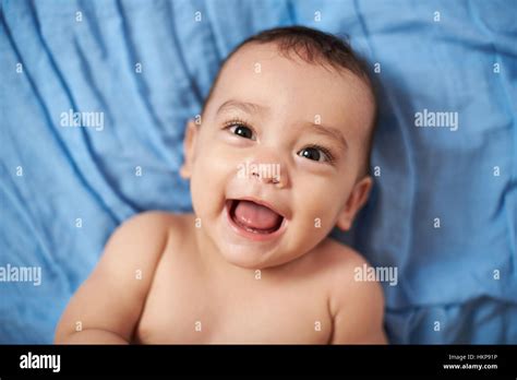 Smiling Baby Laying On Bed Blue Blanket Close Up Stock Photo Alamy