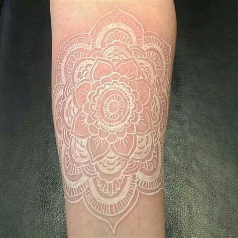 A Womans Leg With A White Tattoo Design On The Side Of Her Arm