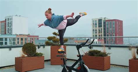 Athletic Girl Performing Swallow Acrobatic Trick Exercises On Cycling