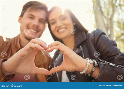 Lovely Couple Holding Hands In Shape Of Heart Outdoors Stock Photo
