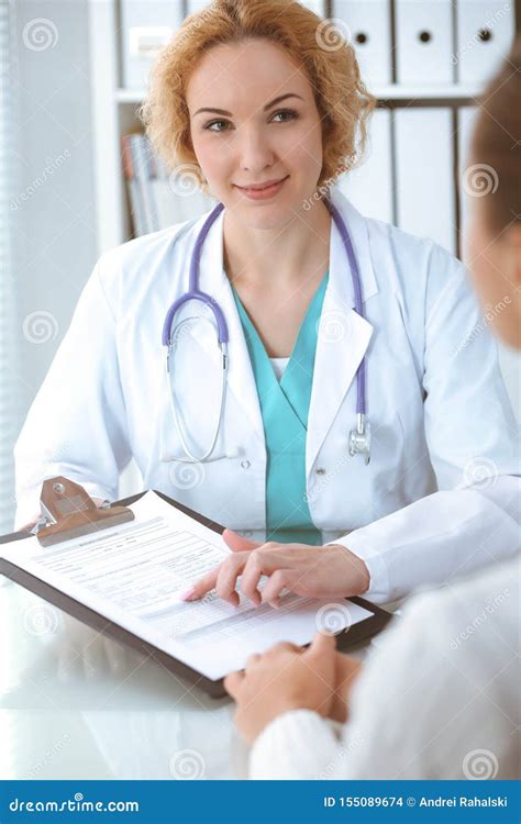 Happy Blonde Female Doctor And Patient Discussing Medical Examination