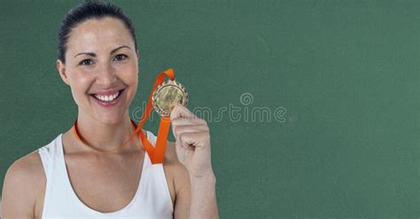 Portrait Of Caucasian Woman Holding Medal Around Her Neck Smiling Against Green Background Stock