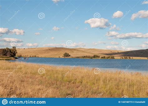 Picturesque Landscape Of Lake And Rolling Hills With Dry Yellow Grass